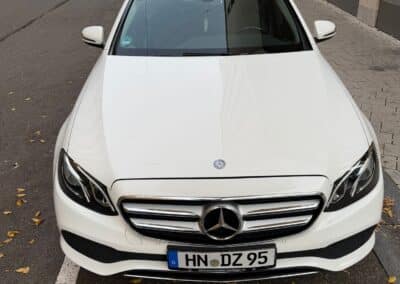 Weißes Mercedes-Benz E-Klasse Taxi, gepflegte Limousine für Business-Fahrten und Flughafentransfer.